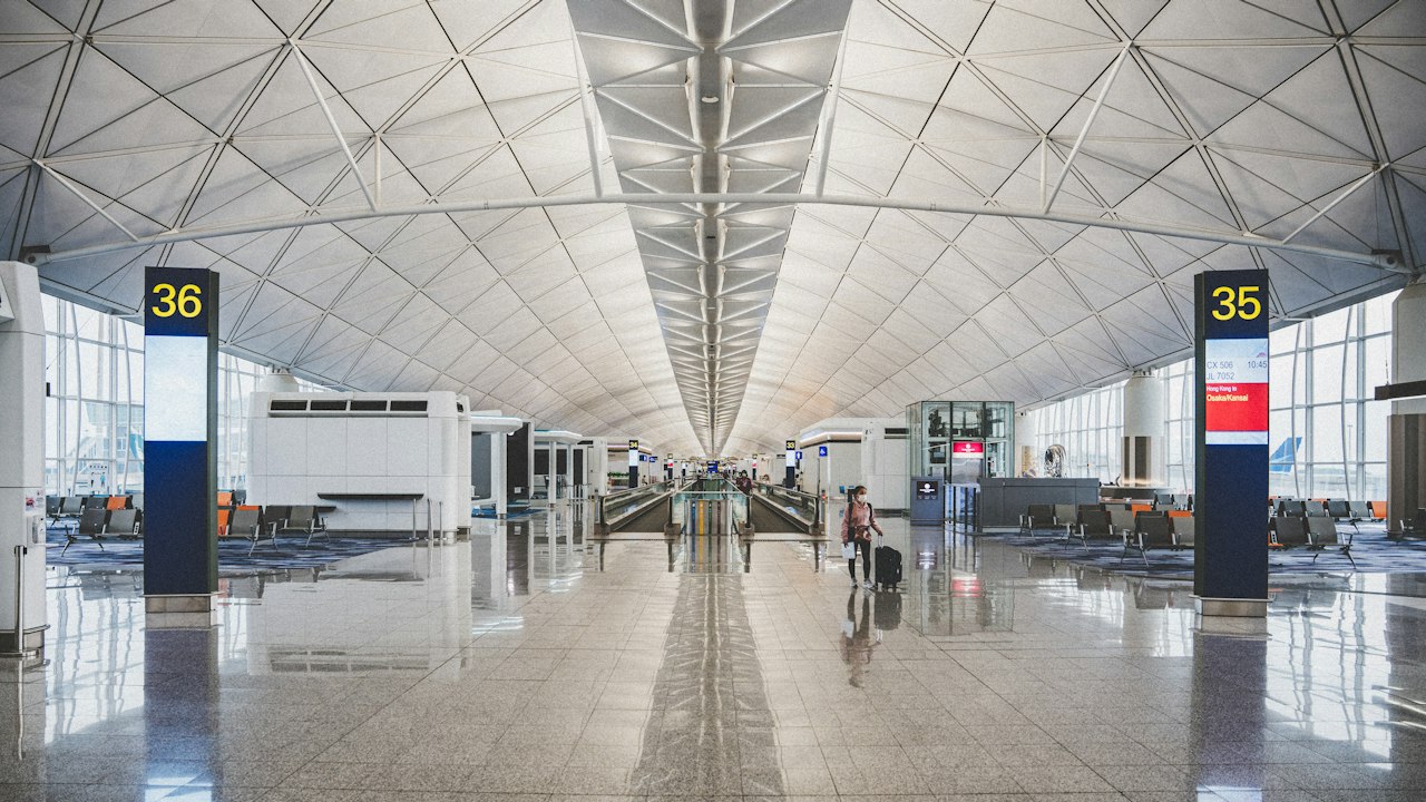 Travellers moving through a bright airport terminal