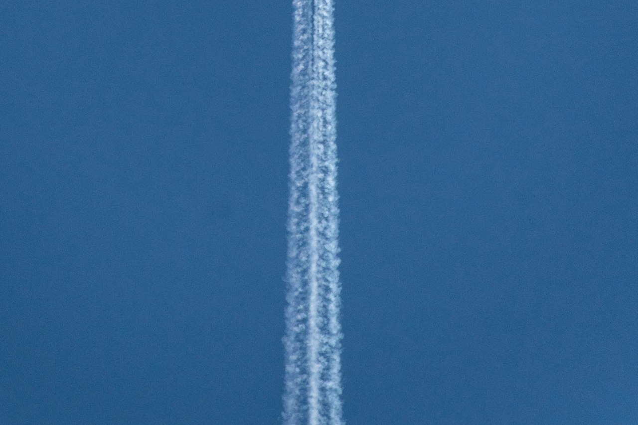 An aircraft contrail crossing a clear sky