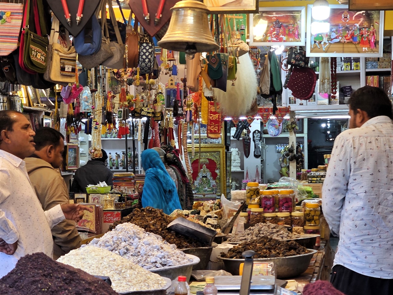 A busy Indian market stall stacked with spices and produce