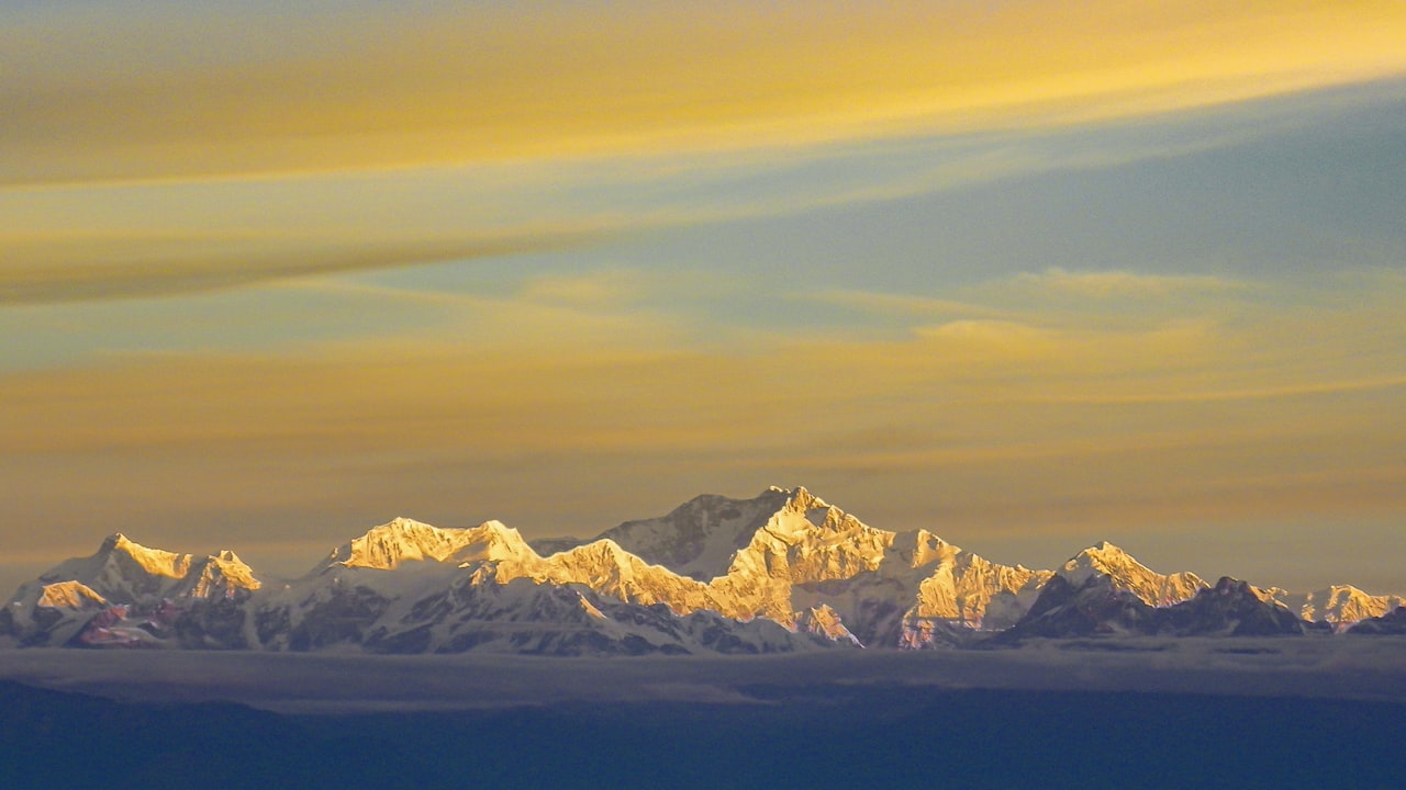 Snow-covered Himalayan peaks lit gold at sunrise