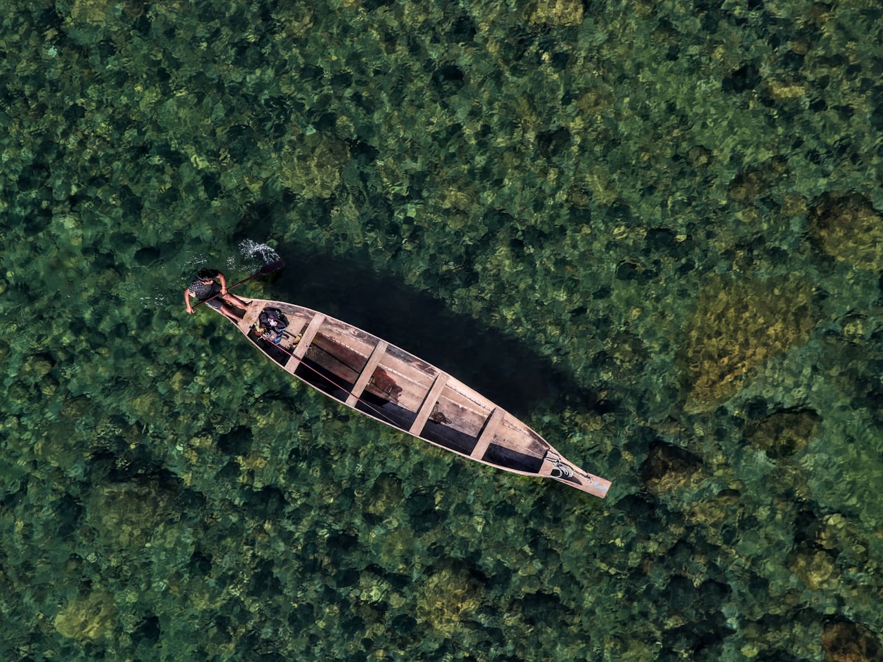 A small boat on clear green water in Northeast India
